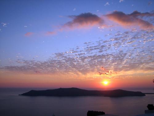 a sunset over a large body of water at Irida - Santorini in Imerovigli