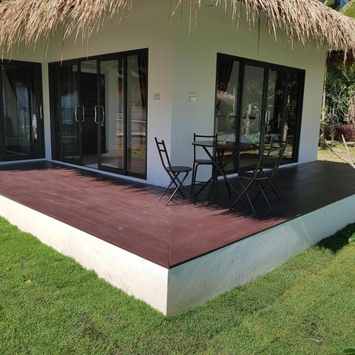 a deck outside of a house with a table and chairs at Sunrise Beach Resort in Ko Chang