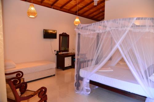 1 dormitorio con 1 cama con mosquitera en Surf Villa, en Hikkaduwa