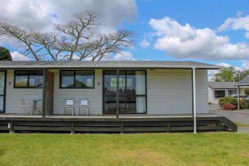 a house with a porch with chairs on it at Holdens Bay Holiday Park in Rotorua