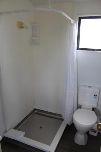 a small bathroom with a toilet and a window at Holdens Bay Holiday Park in Rotorua