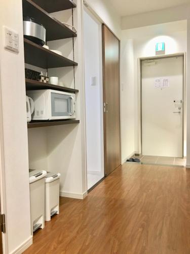 a kitchen with a microwave and a wooden floor at A-Style Futenma in Ginowan