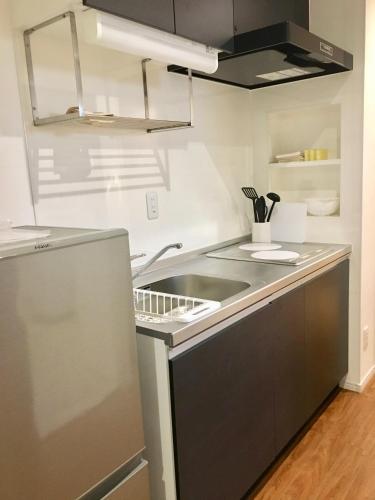a kitchen with a sink and a stove at A-Style Futenma in Ginowan