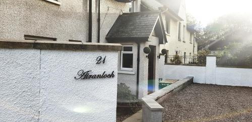 a white building with a sign on the side of it at Airanloch, Loch Ness, Adult Only in Lochend