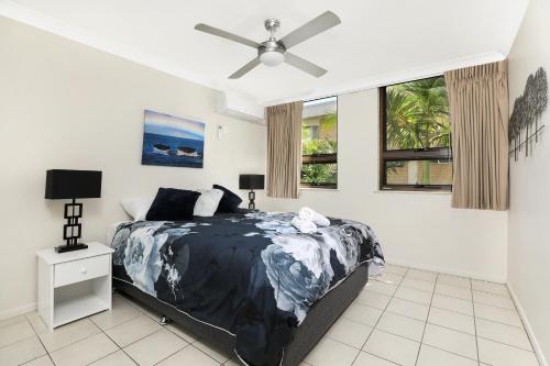 1 dormitorio con 1 cama y ventilador de techo en Headland Tropicana Resort, en Alexandra Headland