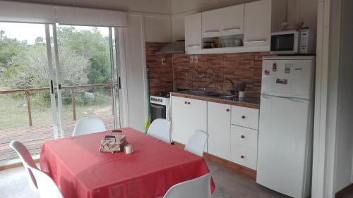 cocina con mesa y mantel rojo en Bramasole Serrano, en Villa Serrana
