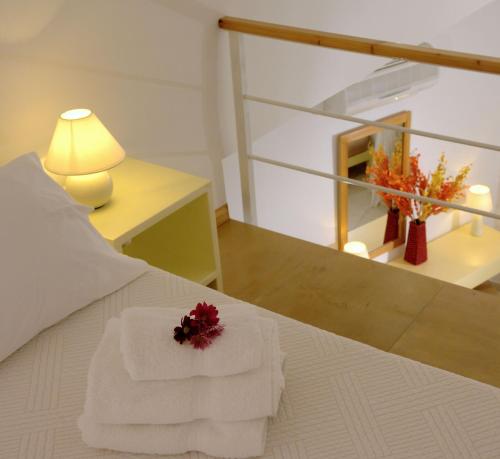 una camera con un letto con due asciugamani e una lampada di Irida - Santorini a Imerovigli