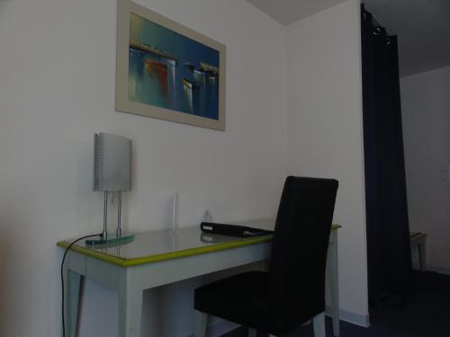 a desk with a chair and a lamp on it at Hotel Princess in Vernet-les-Bains