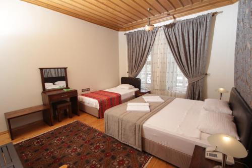 um quarto de hotel com duas camas e uma janela em Konya Dervish Hotel em Konya