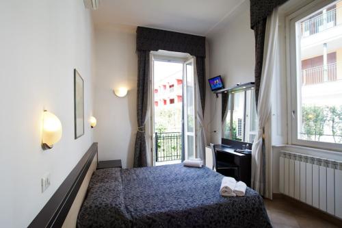 a hotel room with a bed and a window at Hotel Brenta Milano in Milan