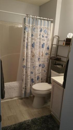 a bathroom with a toilet and a shower curtain at Destin Daydream in Destin