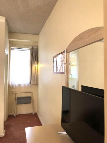 a living room with a tv and a window at The Clarendon Motel Katoomba in Katoomba