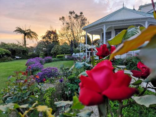 a garden with flowers in front of a house at Country Villa Estate in Ngongotaha