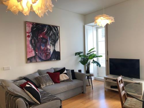 a living room with a couch and a painting on the wall at Mouraria Best Apto in Lisbon