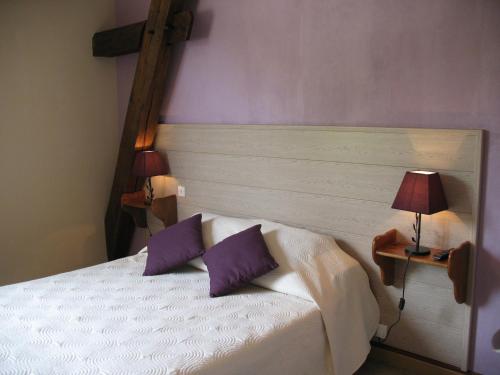 a bed with two pillows and a lamp on top of it at Hôtel Restaurant de l'Abbaye in Clairvaux
