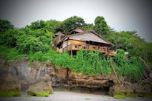 a house sitting on top of a cliff at Cosmos Bungalows in Bira