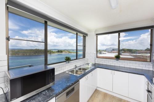 a kitchen with a view of the water at Wharf Street Vista in Forster