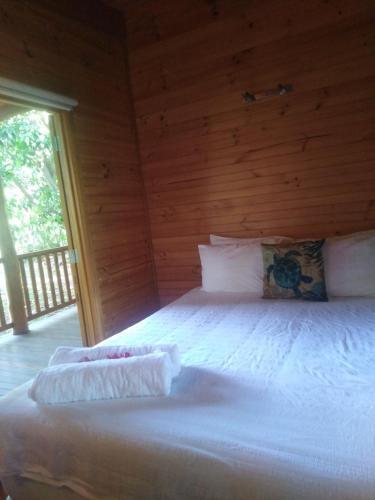 a bedroom with a large white bed with wooden walls at Mango Cottage in Horseshoe Bay