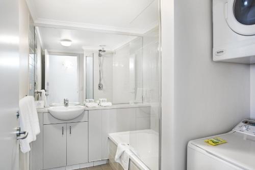 Aligned Corporate Residences Williamstown في ويليامزتاون: حمام أبيض مع حوض ومرحاض