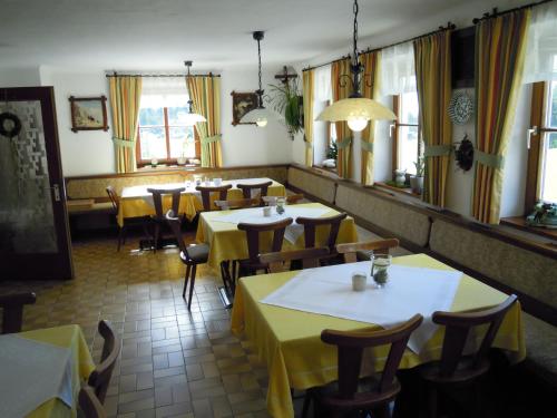a restaurant with tables and chairs with yellow tables at Ferienhaus Höchhäusl in Werfenweng