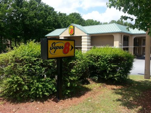 a sign in front of a building with a synergy sign at Super 8 by Wyndham Lithonia in Decatur