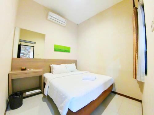 een slaapkamer met een wit bed en een nachtkastje bij The Batu Villas No 5 in Batu