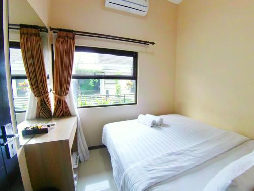 um pequeno quarto com uma cama e uma janela em The Batu Villas No 5 em Batu