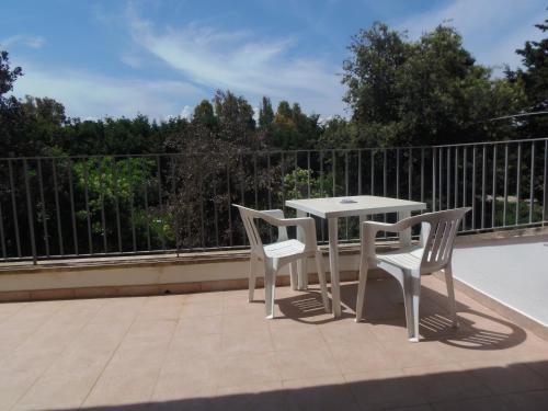 a white table and two chairs on a balcony at Missipezza Residence a Frassanito in Alimini