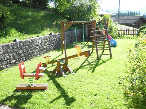 a playground in a yard with a rock wall at Ferienhaus Höchhäusl in Werfenweng