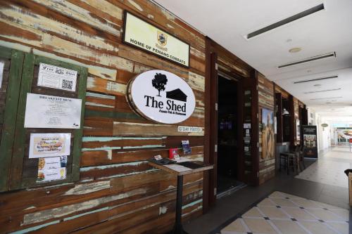 a building with a wooden wall with a sign on it at The Straits Quay Marina by Messina Clive in George Town