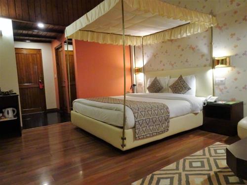 نزل هوني مون شيملا في شيملا: غرفة نوم مع سرير مظلة في غرفة