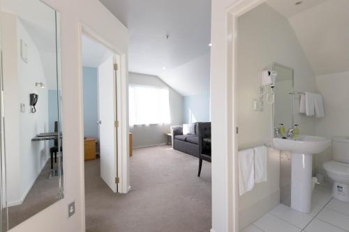 a bathroom with a sink and a toilet in a room at Riccarton Motor Lodge in Christchurch