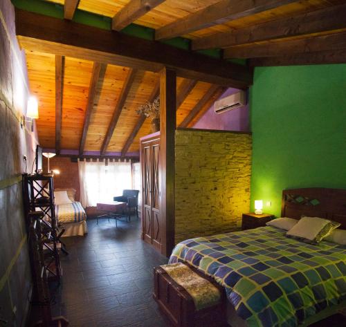 a bedroom with a bed and a green wall at La Casona del Abuelo Parra in Villanueva de los Infantes