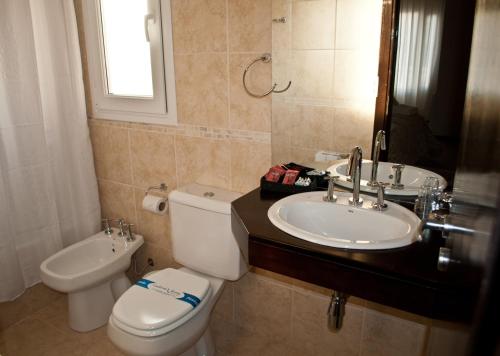 a bathroom with a toilet and a sink at Hotel Aires de Tandil in Tandil