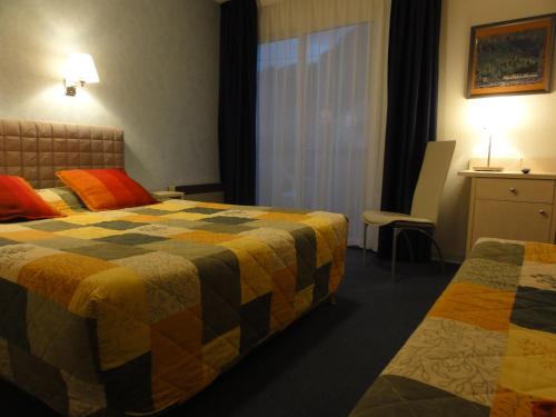 a hotel room with two beds and a window at Hotel Princess in Vernet-les-Bains