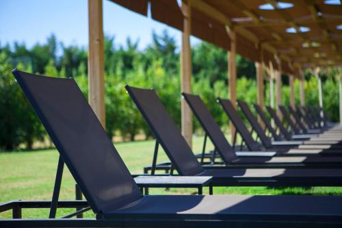 une rangée de chaises longues assises sous un pavillon dans l'établissement URH - Hotel Molí del Mig, à Torroella de Montgrí