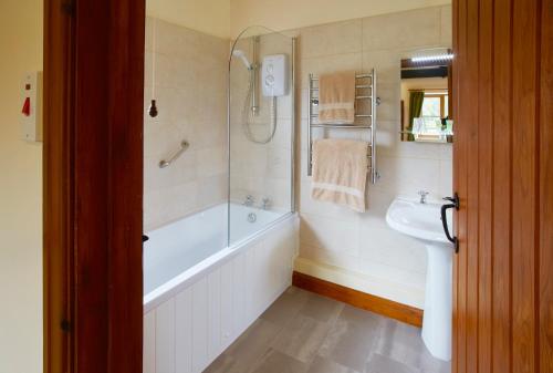 a bathroom with a bath tub and a sink at Rawcliffe House Farm in Pickering