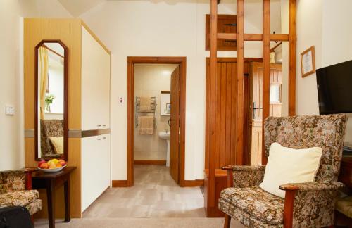 a living room with a chair and a mirror at Rawcliffe House Farm Studios, Peaceful North York Moors Retreat in Pickering