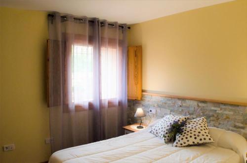 1 dormitorio con cama y ventana en Casa Taraganya, en Beceite