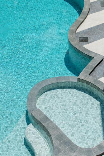 a swimming pool with a statue in the water at Kokotel Khao Lak Lighthouse in Khao Lak