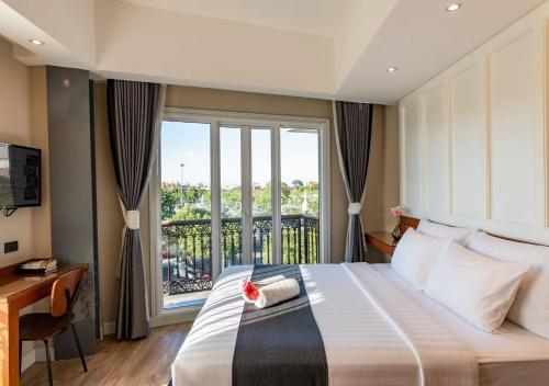 a bedroom with a large bed and a window at Dang Derm In The Park Khaosan in Bangkok