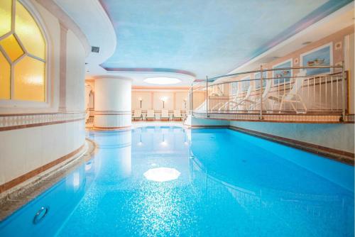 ein Pool mit blauem Wasser in einem Gebäude in der Unterkunft Hotel Residence Rose in Sterzing