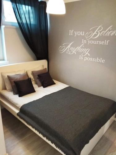 a bedroom with a bed with the words if you believe in yourself everything is possible at Apartment Oscar in Warsaw