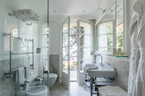 a bathroom with two sinks and a glass shower at Villa della Pergola Relais et Chateaux in Alassio