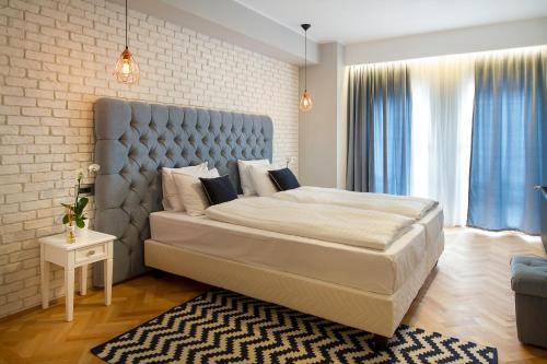 a bedroom with a large bed and a brick wall at Venis Boutique Hotel in Bucharest