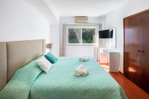een slaapkamer met een groot bed en handdoeken bij Quinta Golf & Beach House in Quinta do Lago