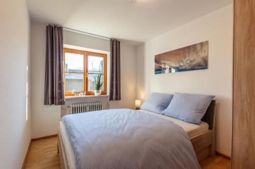 a bedroom with a bed and a window at Ferienwohnungen Alpentraum - Hirschsprung in Bolsterlang