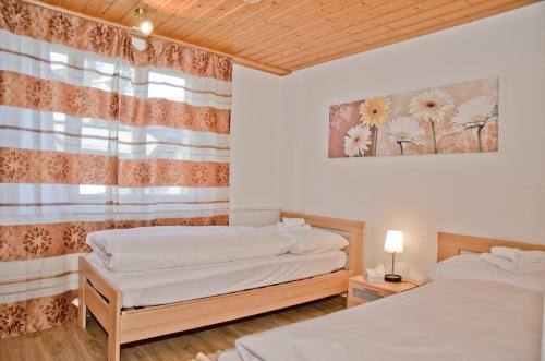 two twin beds in a room with a window at Apartment Neuenhaus - GRIWA RENT AG in Grindelwald