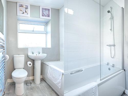 a bathroom with a toilet and a tub and a sink at Abertawe Liberty Stadium in Swansea