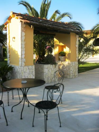 a patio with a table and chairs in front of a building at Hotel Tenuta San Francesco in Barletta